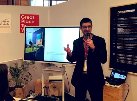 IA, transformation digitale, co-working - super héros de l’entreprise du futur Un homme en costume s'adresse à l'audience lors d'une conférence.
