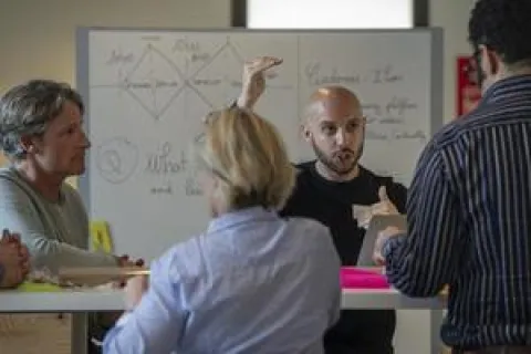 Immersion en start-up Des personnes assises autour d'une table en train de tenir une réunion
