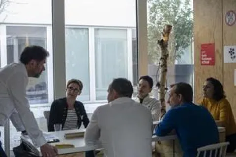 Immersion en start-up Des personnes assises autour d'une table en train de tenir une réunion